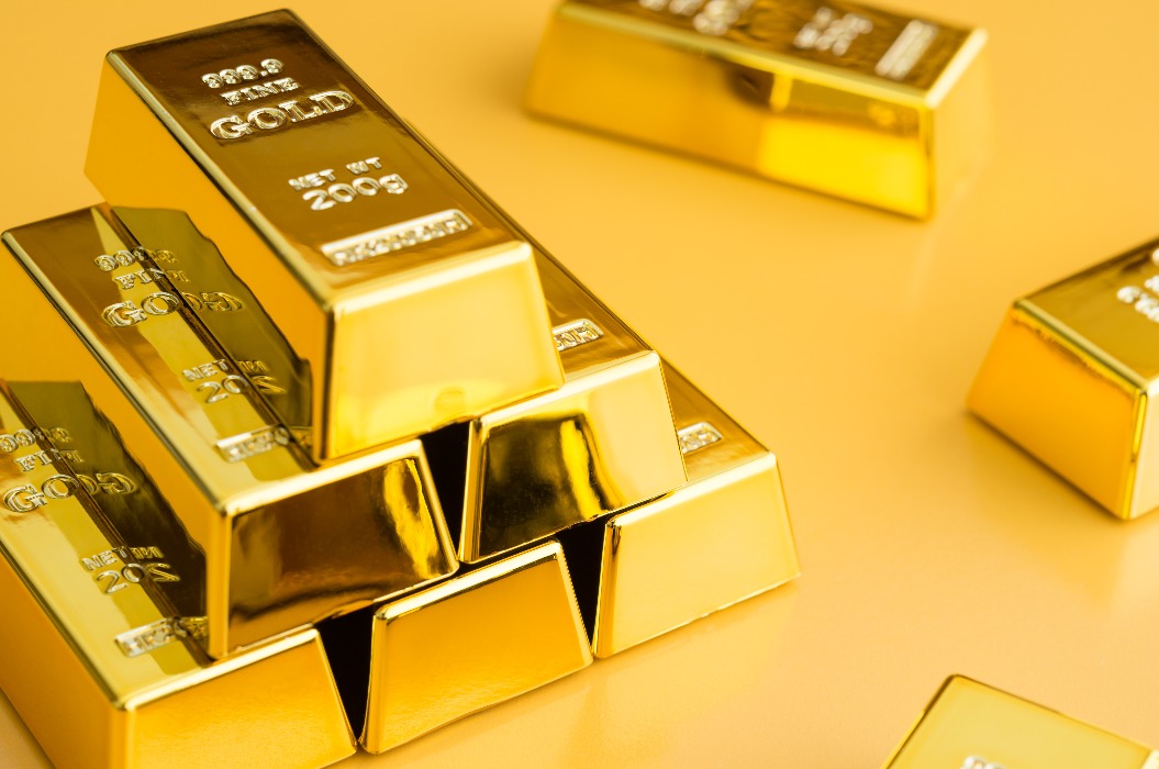 Goldbarren oder Goldbarrenstapel auf gelbem Hintergrund, als Symbol für den Goldpreis