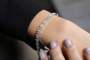 Frau  mit  lackierten  Naegeln  traegt  ein  funkelndes  Diamantarmband  am  Handgelenk
